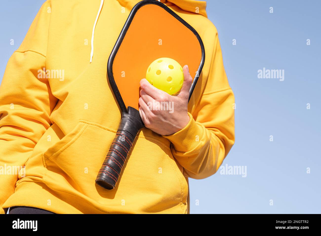 Pickleball paddle et le ballon jaune gros plan, femme jouant au jeu de ...