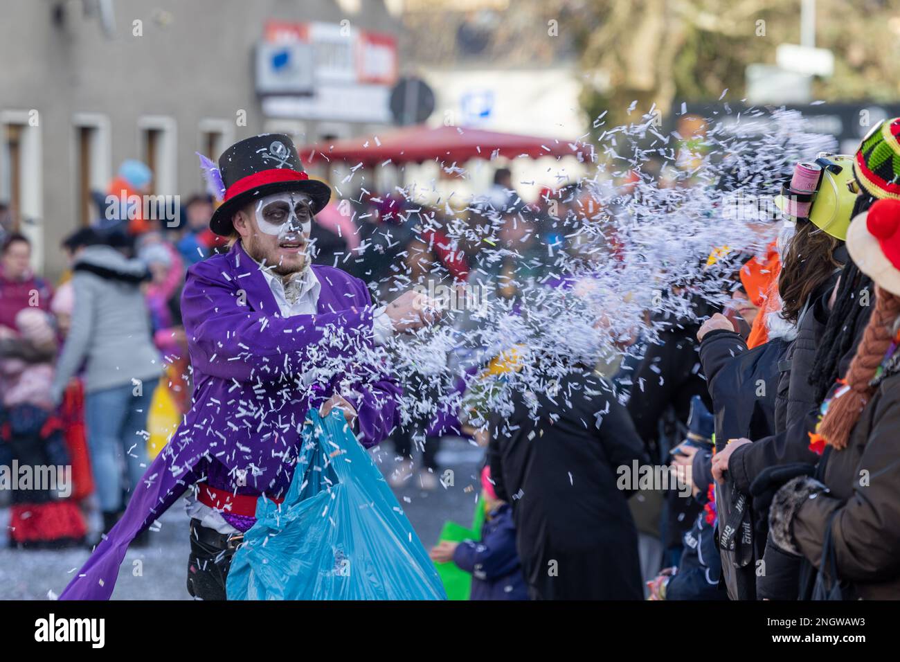 Radeburg, Allemagne. 19th févr. 2023. Un homme jette des confettis dans la foule debout près de la route à la parade du carnaval dans la petite ville saxonne de Radeburg. Cette parade est l'une des plus grandes de ce genre dans toute la Saxe. Credit: Daniel Schäfer/dpa/Alay Live News Banque D'Images