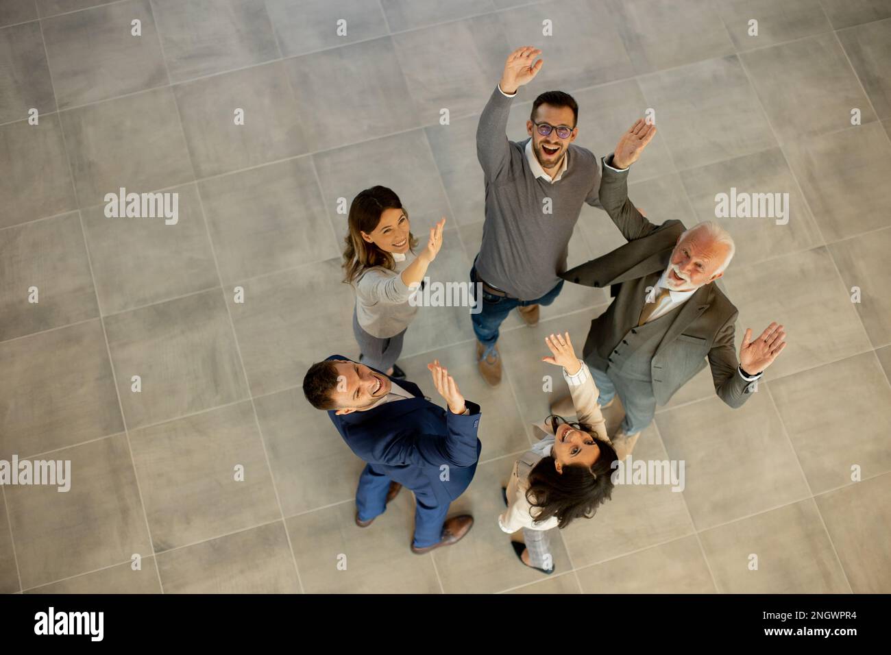 La vue aérienne des gens d'affaires heureux lève les mains avec joie et succès dans le couloir du bureau. Concept de réussite et de travail d'équipe Banque D'Images