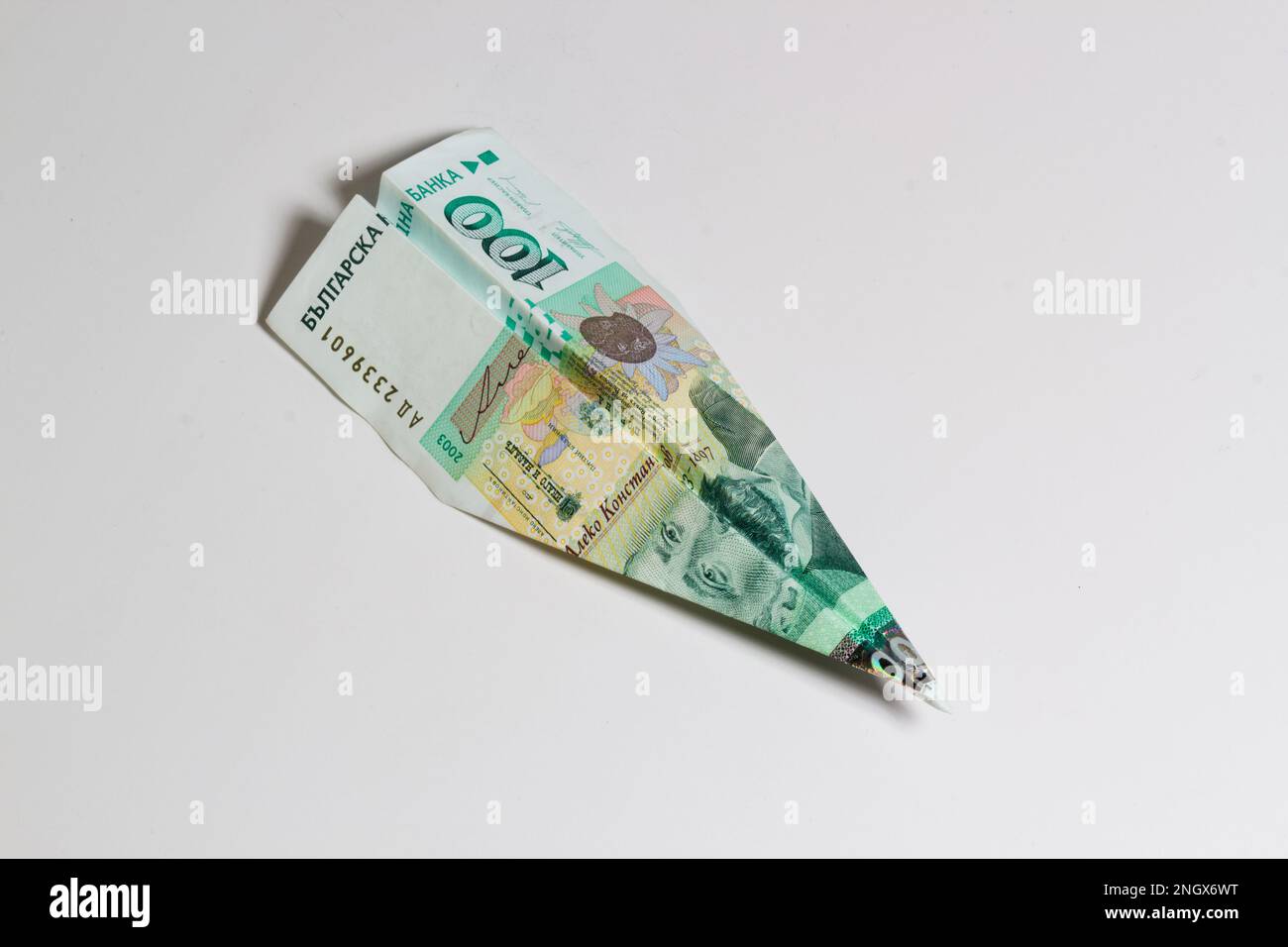 Billet de banque bulgare en argent plié dans un avion isolé sur fond blanc. Transfert d'argent express BGN ou paiement bancaire. Frais de voyage en Bulgarie. Banque D'Images