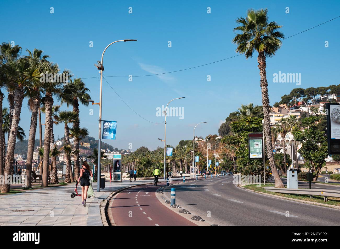 Malaga, Espagne - 14 janvier 2023: Vue sur la rue de la plage avec des personnes marchant ou faisant du vélo sur le trottoir Banque D'Images Malaga, Espagne - 14 janvier 2023: Vue sur la rue de la plage avec des personnes marchant ou faisant du vélo sur le trottoir Banque D'Images
