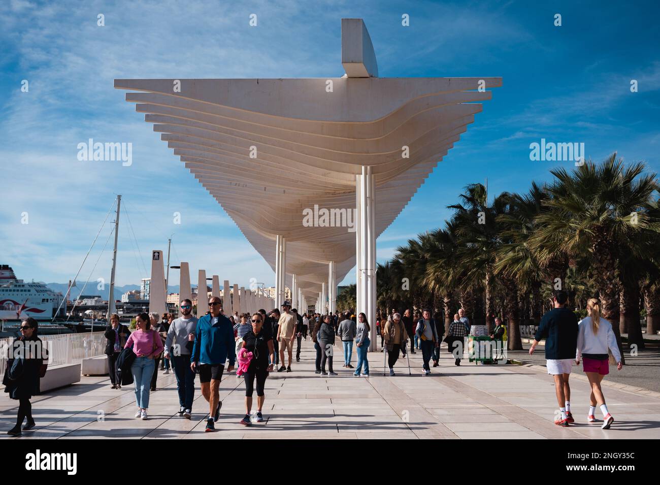 Malaga, Espagne - 15 janvier 2023: Personnes marchant sous les Pérgolas de la Victoria (espagnol pour les Pergolas de Victoria) à la jetée Banque D'Images Malaga, Espagne - 15 janvier 2023: Personnes marchant sous les Pérgolas de la Victoria (espagnol pour les Pergolas de Victoria) à la jetée Banque D'Images