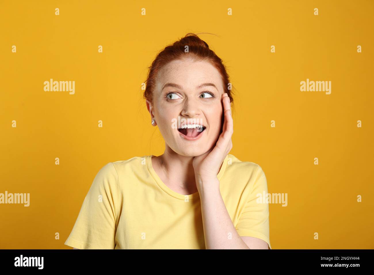 Portrait de la femme émotif aux cheveux rouges sur fond jaune Banque D'Images