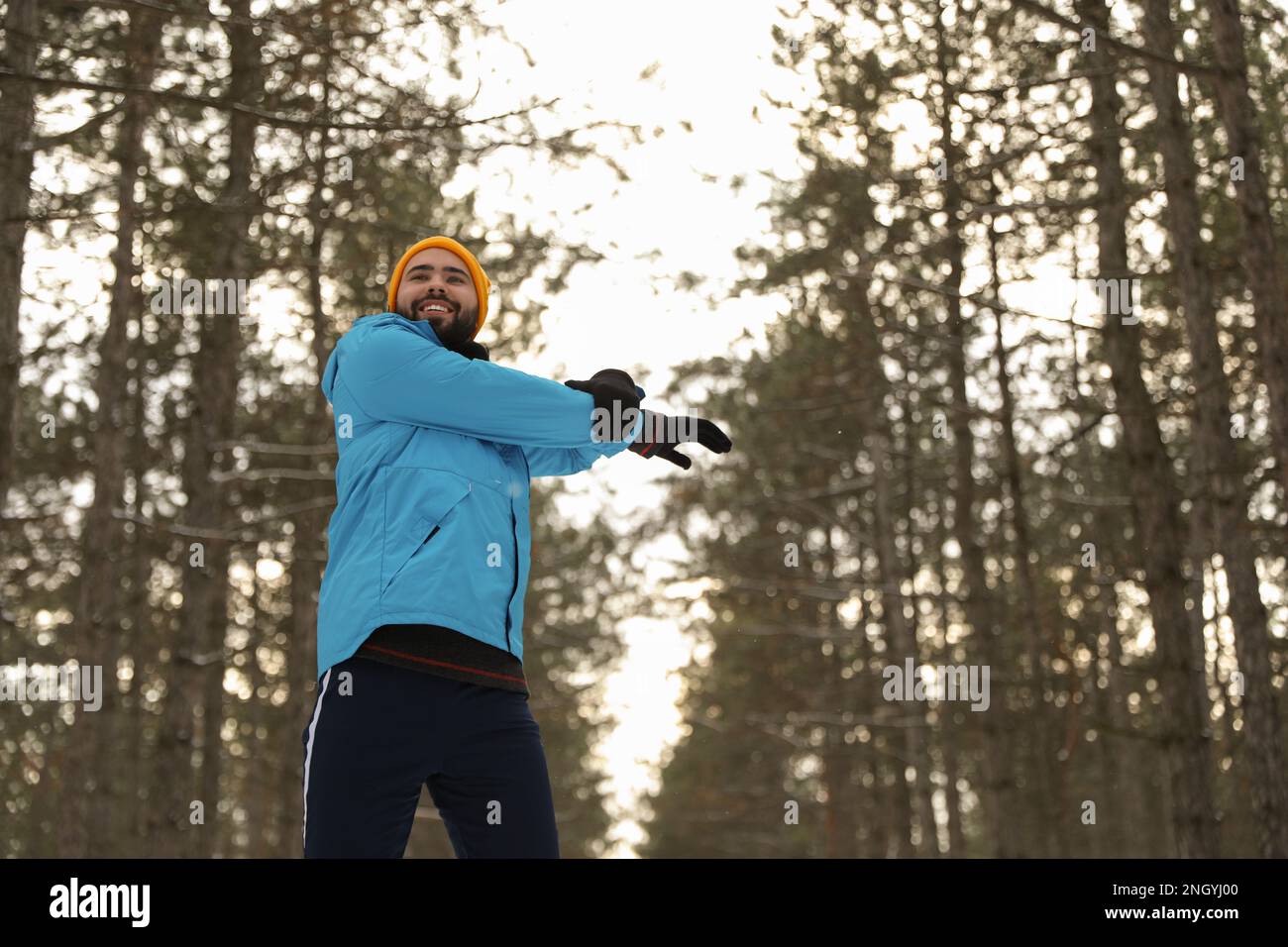 Homme faisant des exercices de sport dans la forêt d'hiver, vue à angle bas Banque D'Images