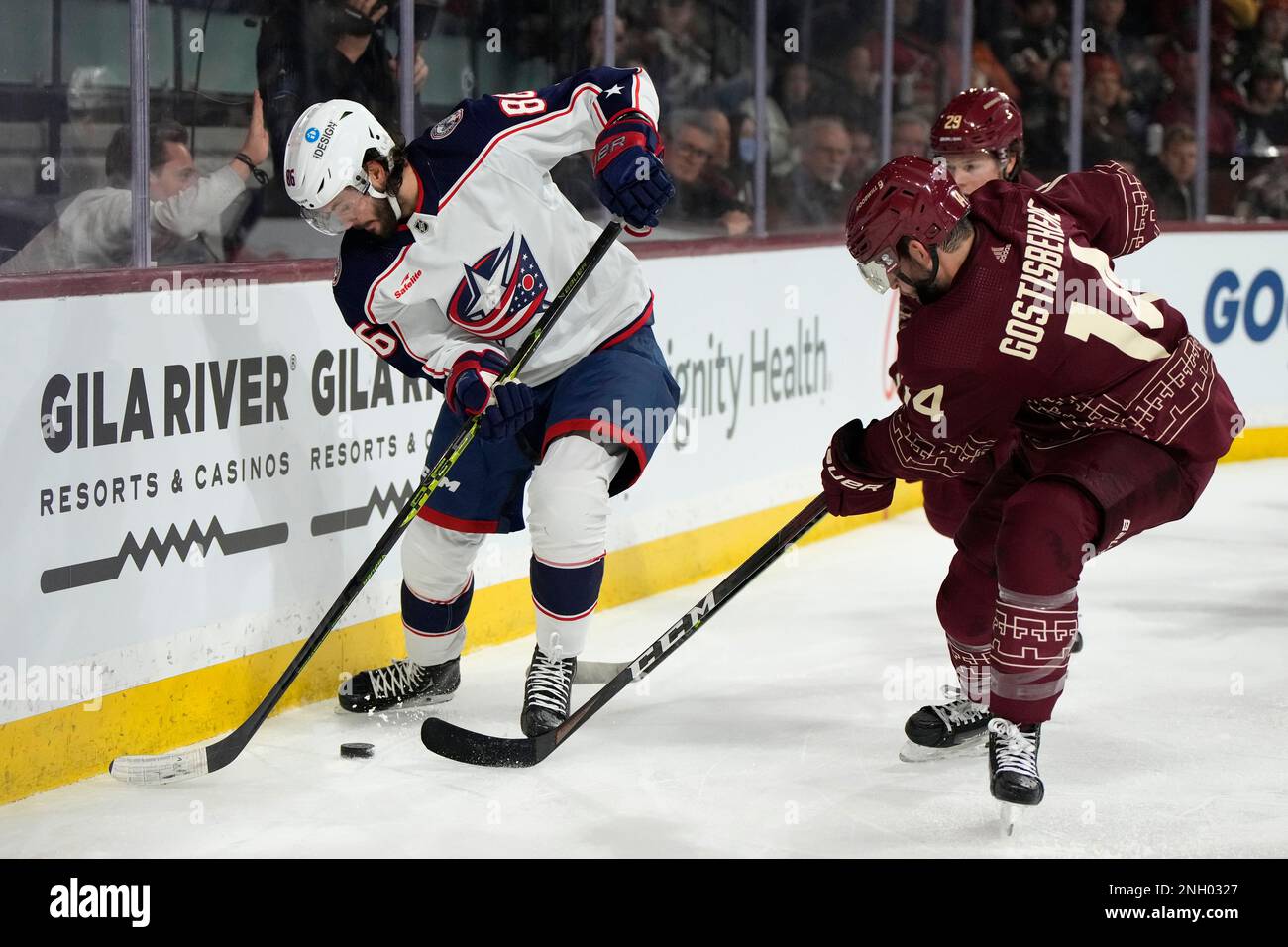Columbus Blue Jackets right wing Kirill Marchenko (86) shields the puck from Arizona Coyotes center Barrett Hayton and defenseman Shayne Gostisbehere (14) during the second period of an NHL hockey game Sunday, Feb. 19, 2023, in Tempe, Ariz. (AP Photo/Rick Scuteri) Banque D'Images