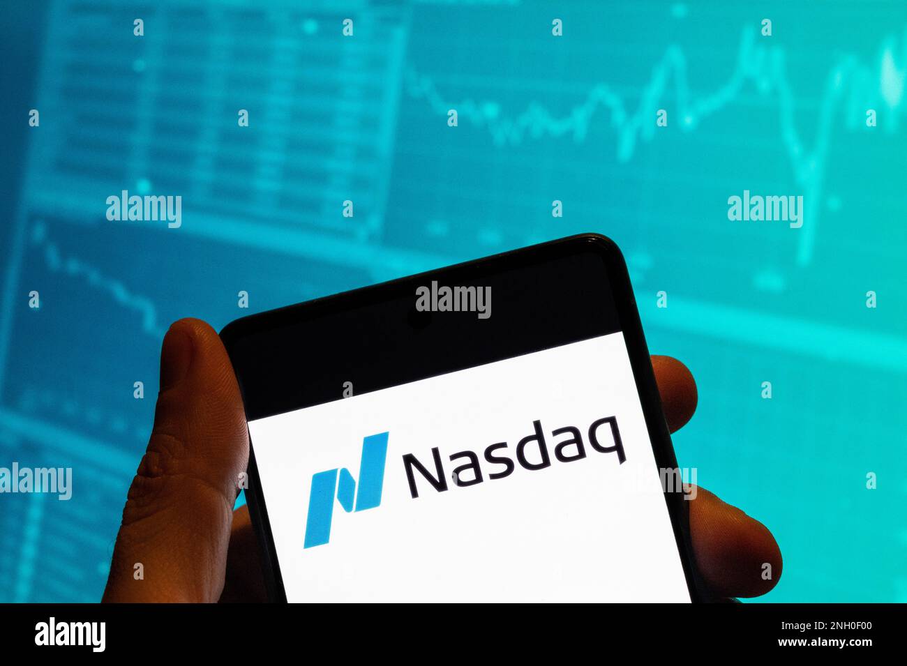 Chine. 15th févr. 2023. Dans cette illustration, l'indice boursier américain, le logo Nasdaq, est affiché sur un smartphone avec un graphique d'indice boursier économique en arrière-plan. Crédit : SOPA Images Limited/Alamy Live News Banque D'Images