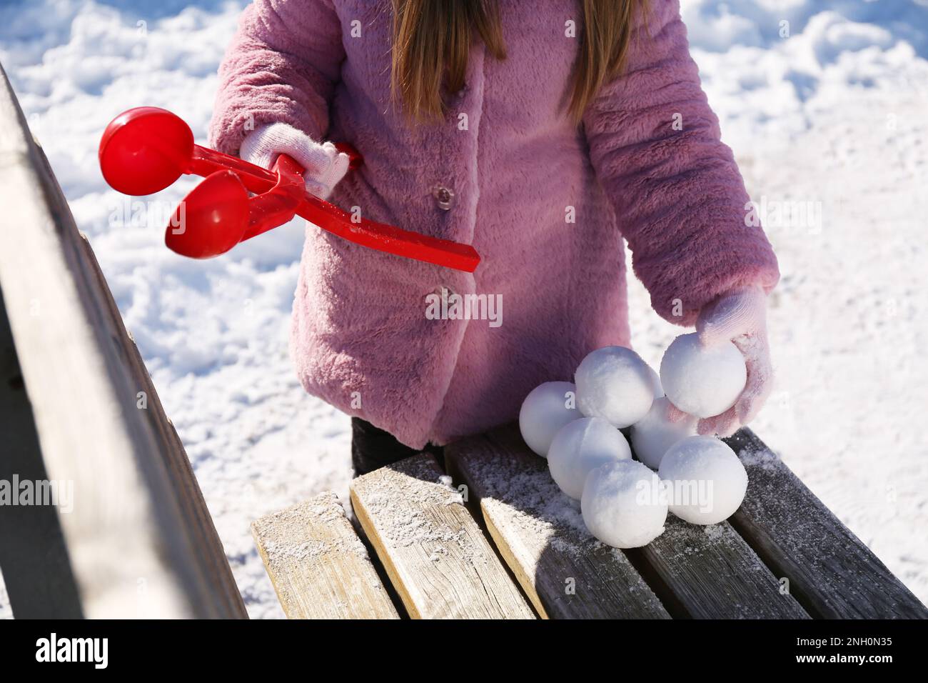 Petite fille jouant avec le fabricant de boules de neige à l'extérieur, gros plan Banque D'Images
