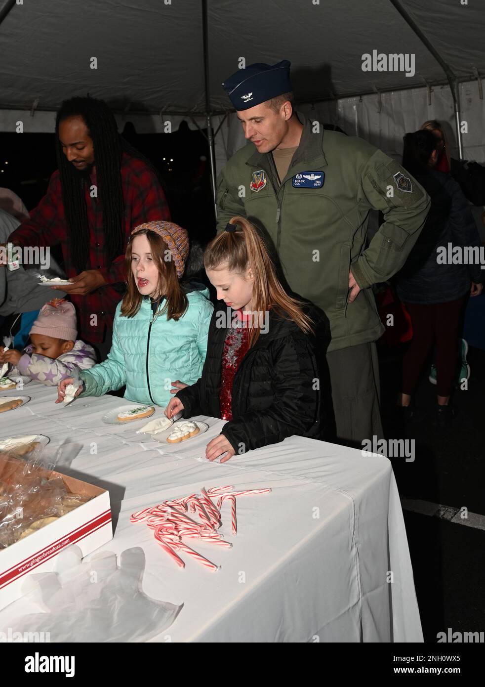 Le colonel Lucas Teel, commandant de l'escadre du 4th Fighter, observe les enfants décorant des biscuits pendant le Holiday Village et le salon des vendeurs à la base aérienne Seymour Johnson, en Caroline du Nord, le 5 décembre 2022. Les festivités comprenaient des divertissements pour les enfants, des spectacles musicaux, la clause Santa et la clause Mme et des stands de vendeurs. Banque D'Images