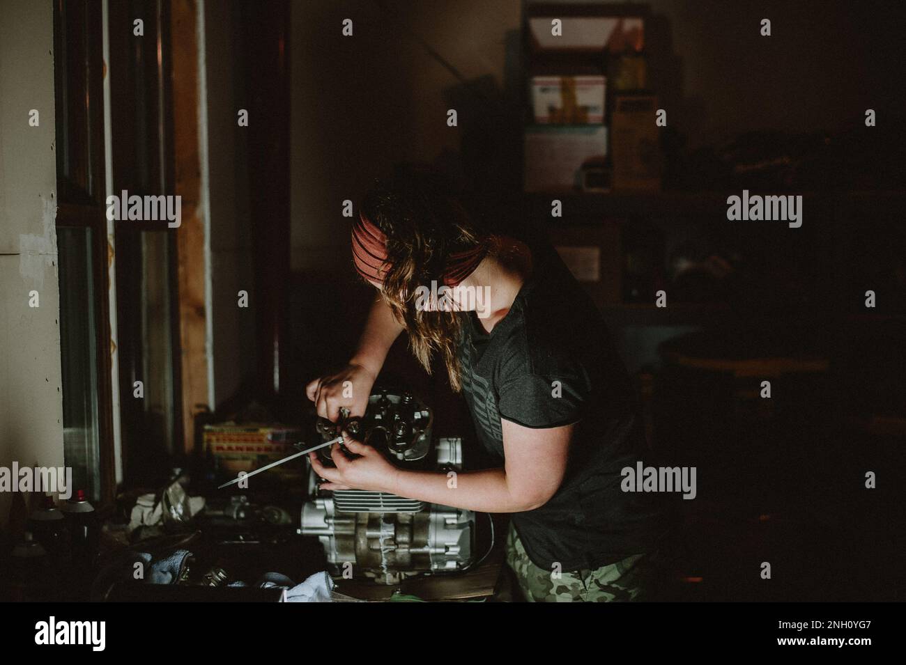 Femme travaillant sur le moteur en atelier. Banque D'Images