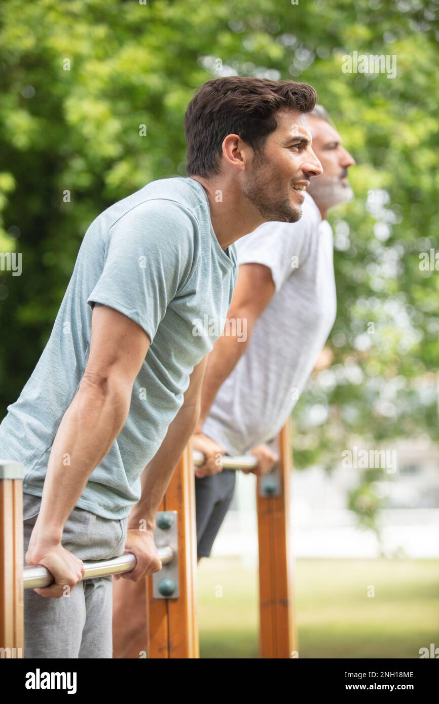 des hommes en salle de gym font des exercices sur la barre horizontale Banque D'Images