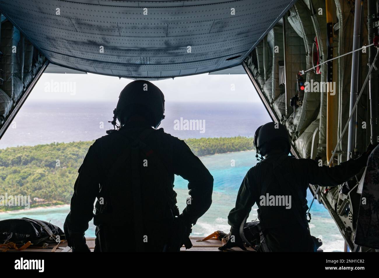 Le Sgt Tatsuhiro Kurimoto, chef de la Force d'autodéfense aérienne du Japon, et le Sgt Ikkei Ono, C-130H Hercules Loadmasters, se préparent à faire sortir un colis au-dessus de l'île du RUO lors de l'opération Christmas Drop, le 6 décembre 2022. L'opération Christmas Drop est une opération annuelle américaine La Force aérienne a pour tradition d'emballer et de livrer des dons de nourriture, de matériel de pêche, de livres scolaires et de vêtements à plus de 20 mille insulaires dans 56 îles éloignées des États fédérés de Micronésie et de la République des Palaos. Banque D'Images