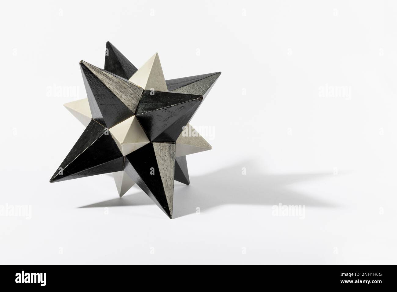 Le dodécaèdre stellaire de couleur grise avec des extrémités pointues qui jettent l'ombre sur un arrière-plan blanc Banque D'Images