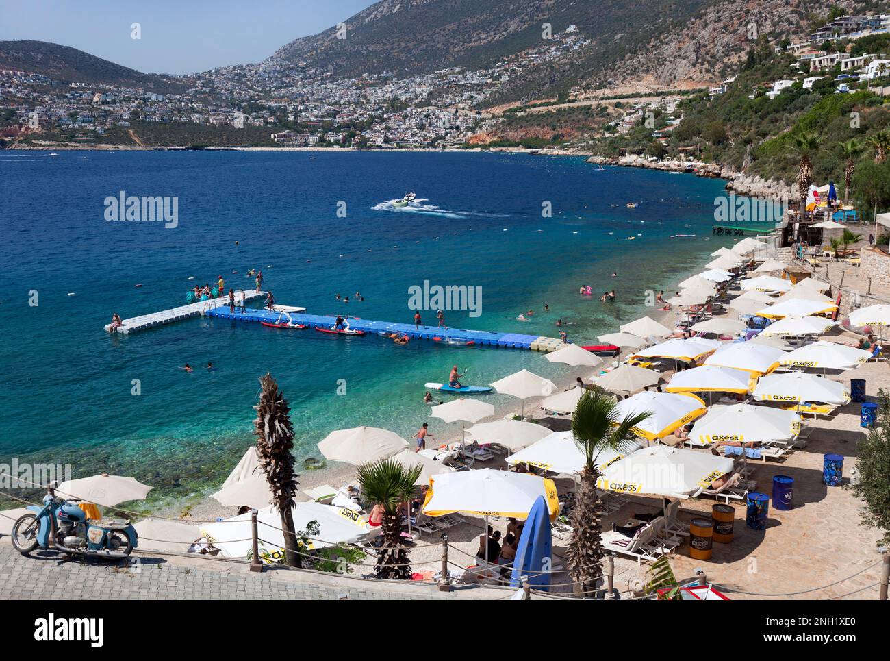 Le club de plage de Kalkan avec le village de Kalkan en arrière-plan. Turquie. Juillet 2022 Banque D'Images