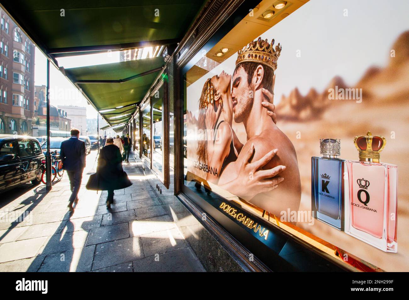 Une scène de rue à l'extérieur du grand magasin Harrods à Knighsbridge, Londres. La fenêtre affiche une fumée de Dolce et Gabbana. Banque D'Images