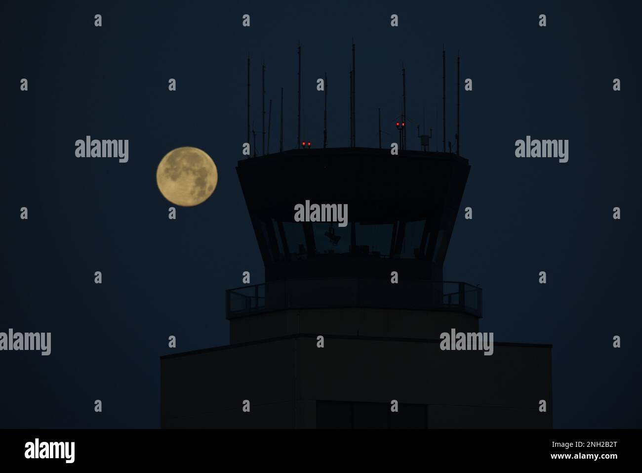 Un ciel dégagé révèle une pleine lune à l'ouest derrière la tour de contrôle de la circulation aérienne lors d'une matinée froide à l'aéroport de Sioux City, Iowa, sur 8 décembre 2022. Avec des températures dans les années de faible adolescence et des vents calmes, c'est le calme avant la tempête dans l'ouest de l'Iowa que les prévisions appellent de la neige l'après-midi et le soir. ÉTATS-UNIS Photo de la Garde nationale aérienne SMSgt Vincent de Groot Banque D'Images