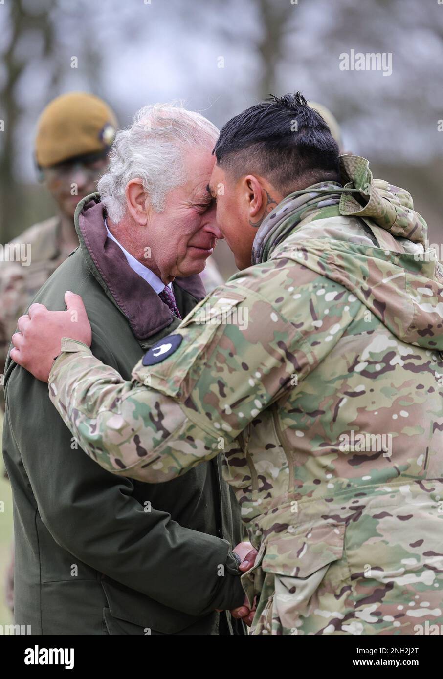 Le roi Charles III reçoit le hongi - l'accueil maori traditionnel - d'un Néo-Zélandais qui fait partie du contingent ukrainien, lors d'une visite à un site d'entraînement pour les recrues militaires ukrainiennes, dans le Wiltshire, Là où les recrues terminent cinq semaines de formation de base au combat par les forces britanniques et internationales partenaires, avant de retourner au combat en Ukraine. Date de la photo: Lundi 20 février 2023. Banque D'Images