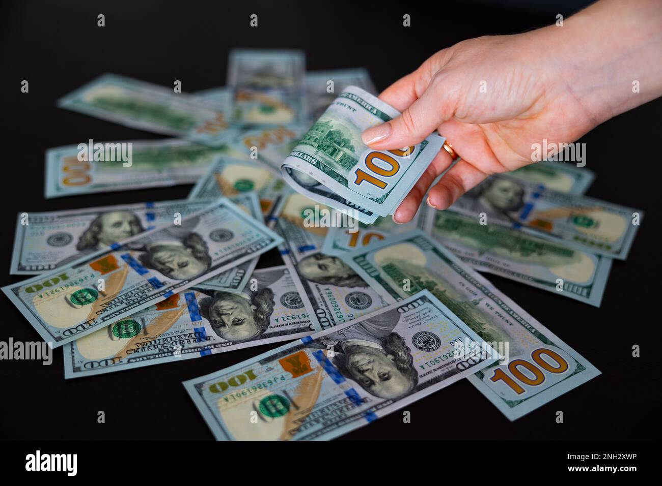 plié cent dollars dans les mains des femmes. Dollars trésorerie sur les billets, ventilateur de 100 dollars, cent dollars Banque D'Images
