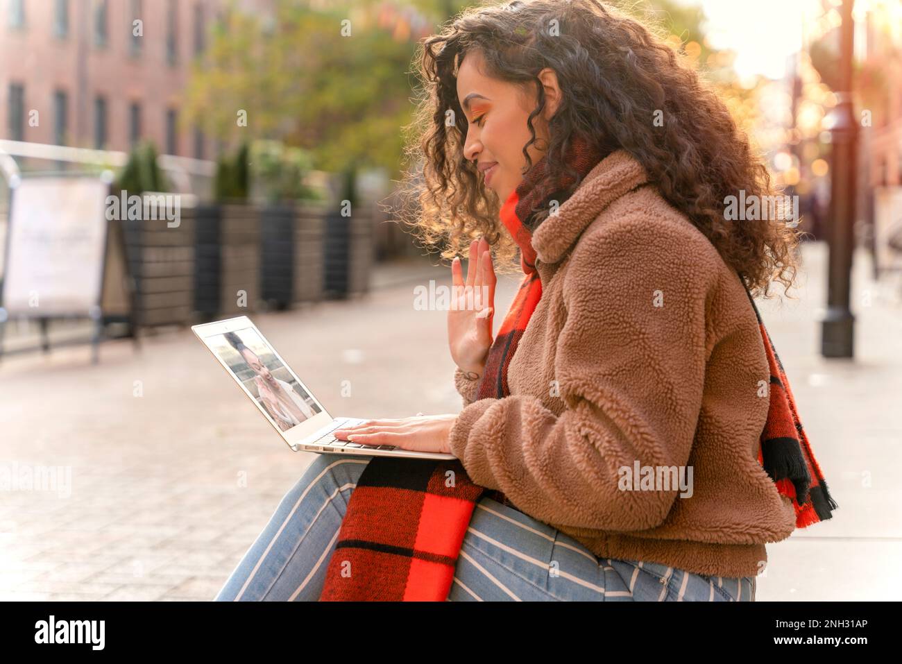 Happy Woman étudiant e-learning formation à distance étude de travail sur les escaliers dans la ville. Une jeune femme africaine d'origine ethnique regardant l'éducation en ligne W Banque D'Images
