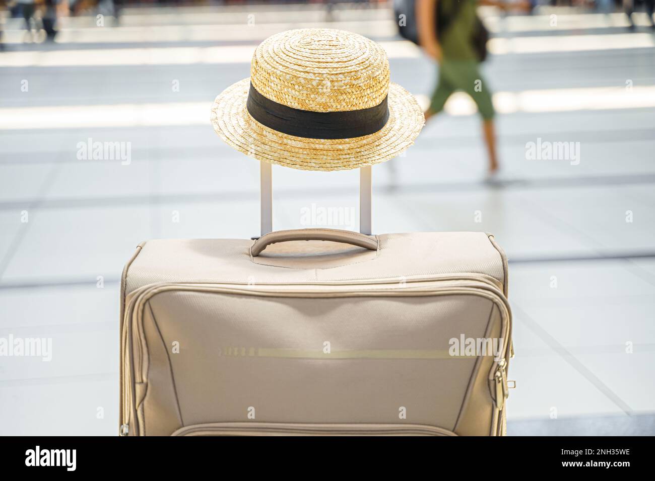 Chapeau de paille dans une grande valise, sac dans le terminal de l'aéroport. En attente de l'embarquement pour le vol. Vacances en famille. Enregistrement des bagages dans le hall des départs. S Banque D'Images
