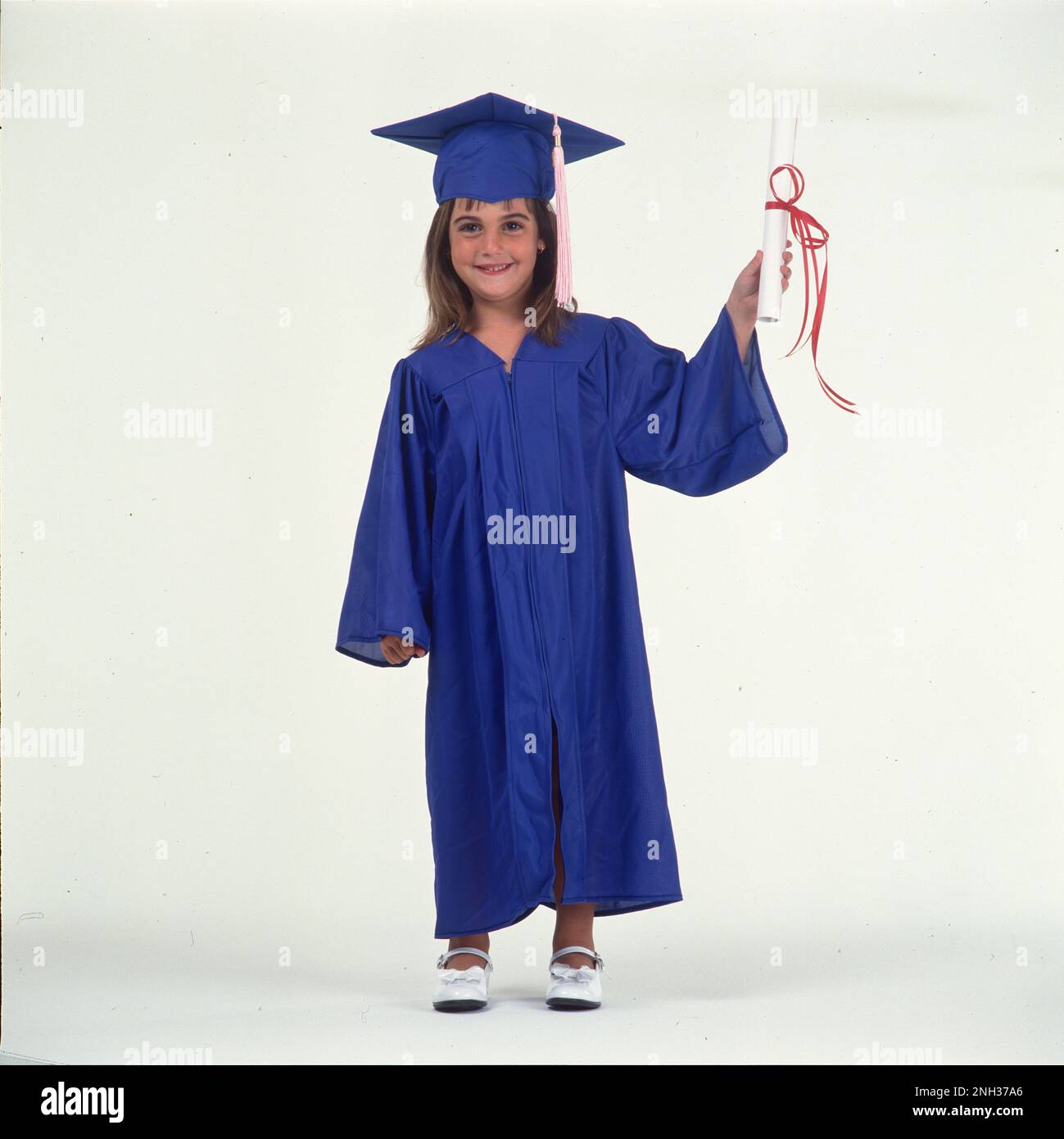 Petite fille en chapeau et robe tenant un diplôme Banque D'Images