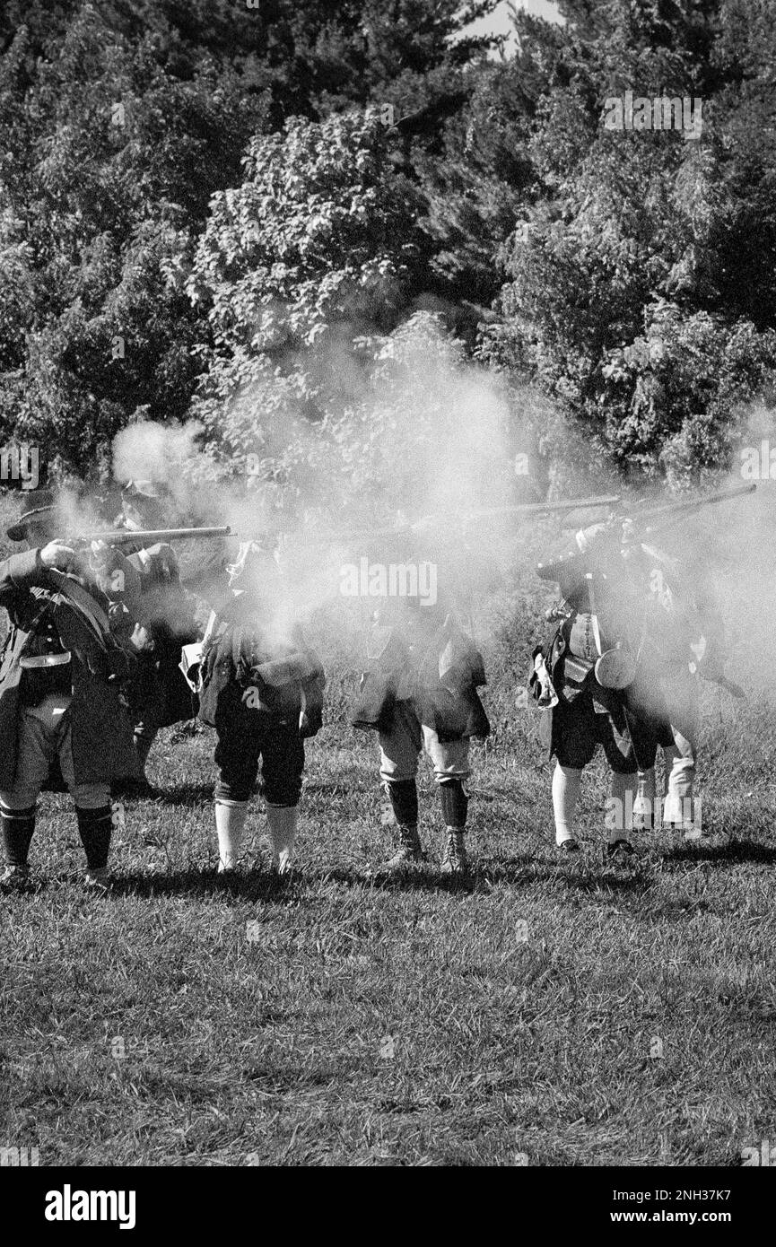 Les soldats coloniaux dans un nuage de fumée incendient leurs mousquets aux soldats de Red Coats (Britanniques) sur le champ de bataille pendant la bataille de Newbury révolutionnaire Banque D'Images