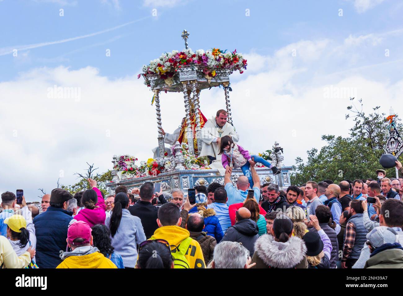 Andujar, province de Jaen, Espagne. Romeria annuelle de la Virgen de la Cabeza. Trône avec la statue de la Virgen et deux prêtres transportés parmi le multit Banque D'Images