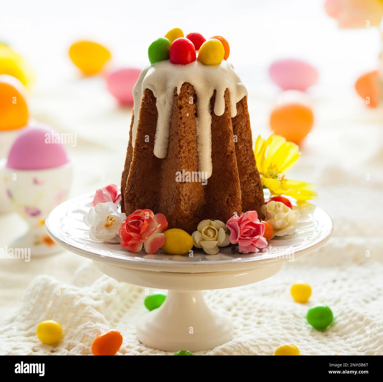 Table de Pâques avec fleurs printanières, gâteaux et œufs de pâques. Banque D'Images