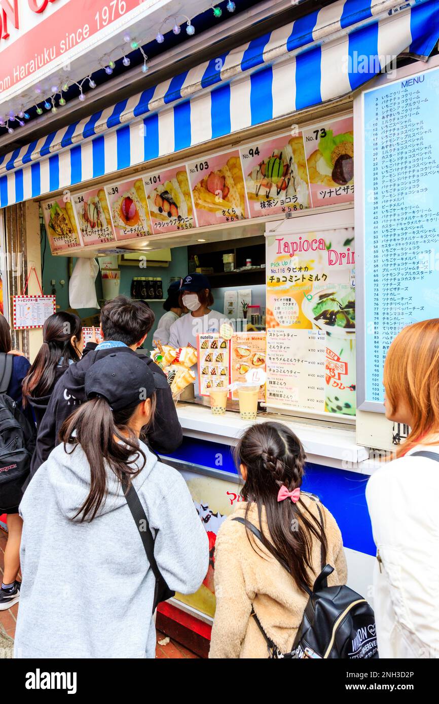 Tokyo, Harajuku, rue Takeshita. Marion Crepe enrater avec des gens qui font la queue au comptoir en attendant de commander et d'être servis leurs crêpes. Gros plan. Banque D'Images