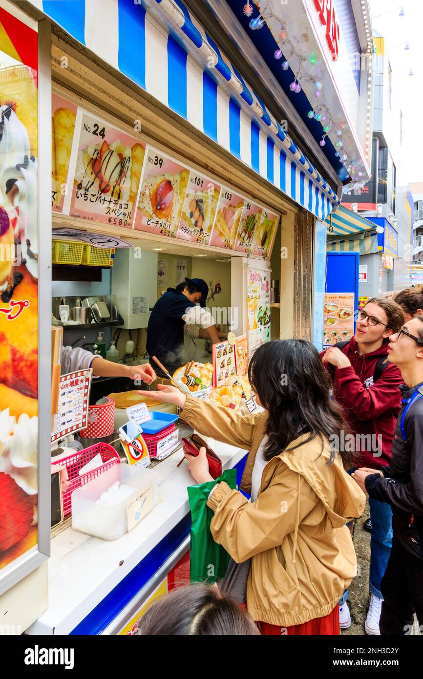 Tokyo, Harajuku, rue Takeshita. Marion Crepe enrater avec des gens qui font la queue au comptoir en attendant de commander et d'être servis leurs crêpes. Gros plan. Banque D'Images