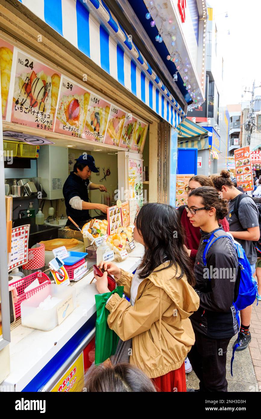 Tokyo, Harajuku, rue Takeshita. Marion Crepe enrater avec des gens qui font la queue au comptoir en attendant de commander et d'être servis leurs crêpes. Gros plan. Banque D'Images