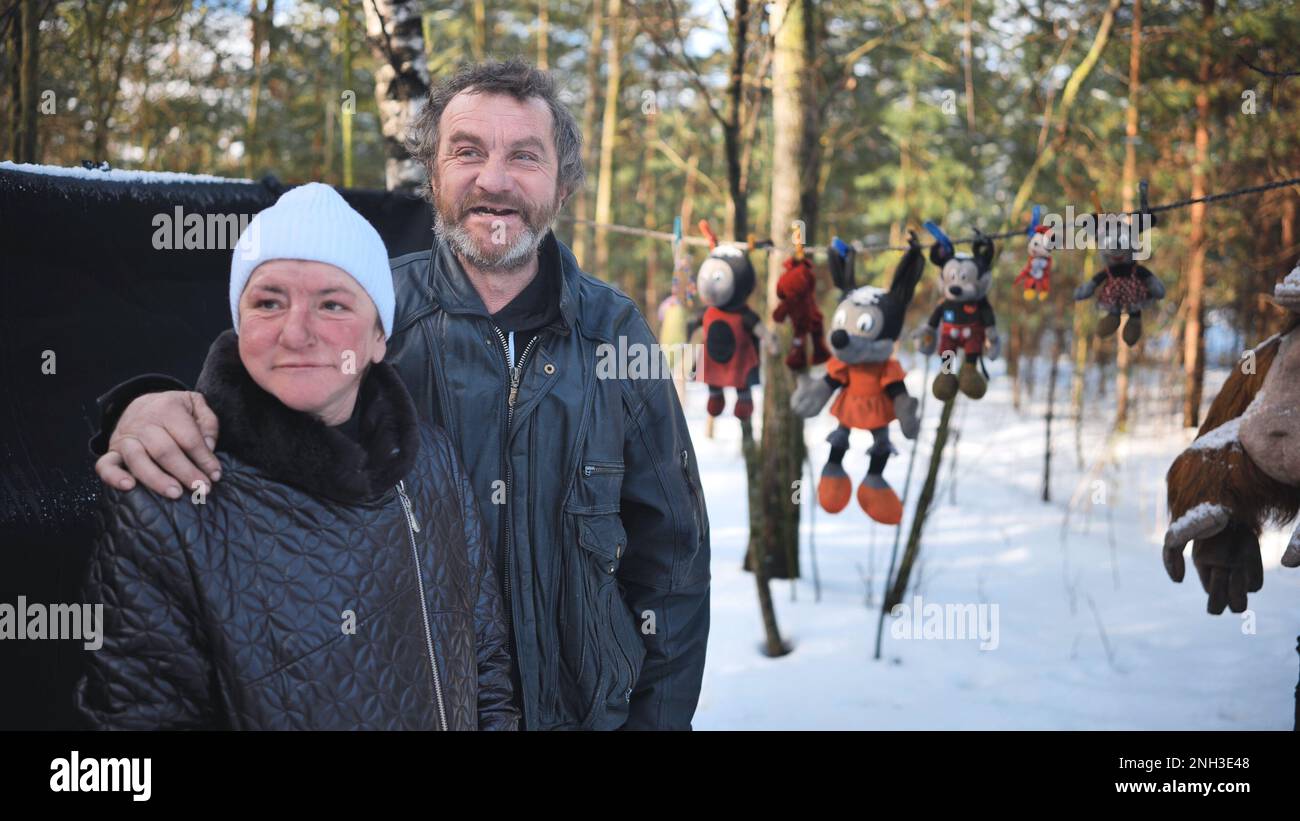 Un homme et une femme sans domicile donnant une interview en hiver dans les bois. Banque D'Images