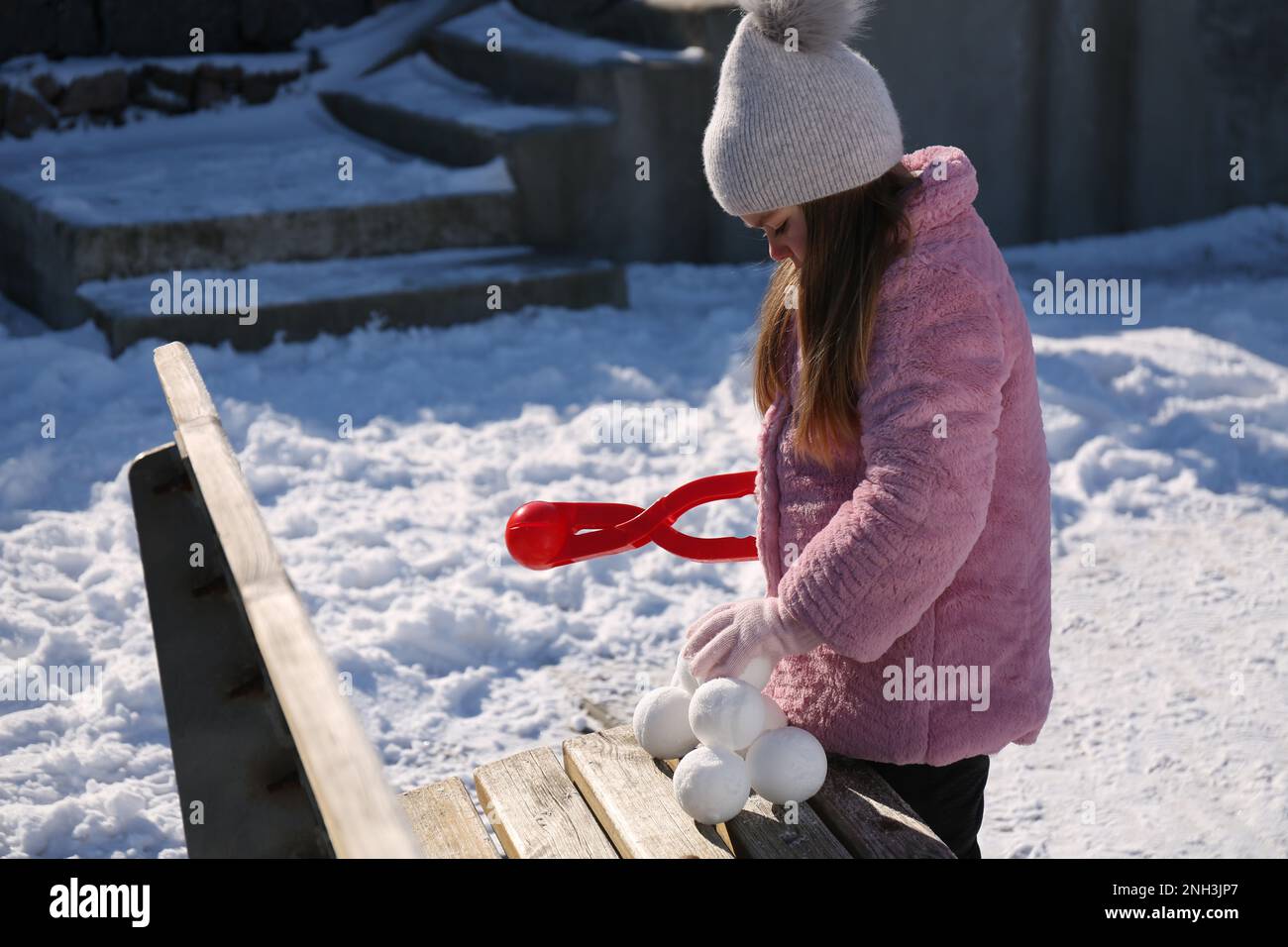 Adorable petite fille jouant avec le snowball Maker à l'extérieur Banque D'Images