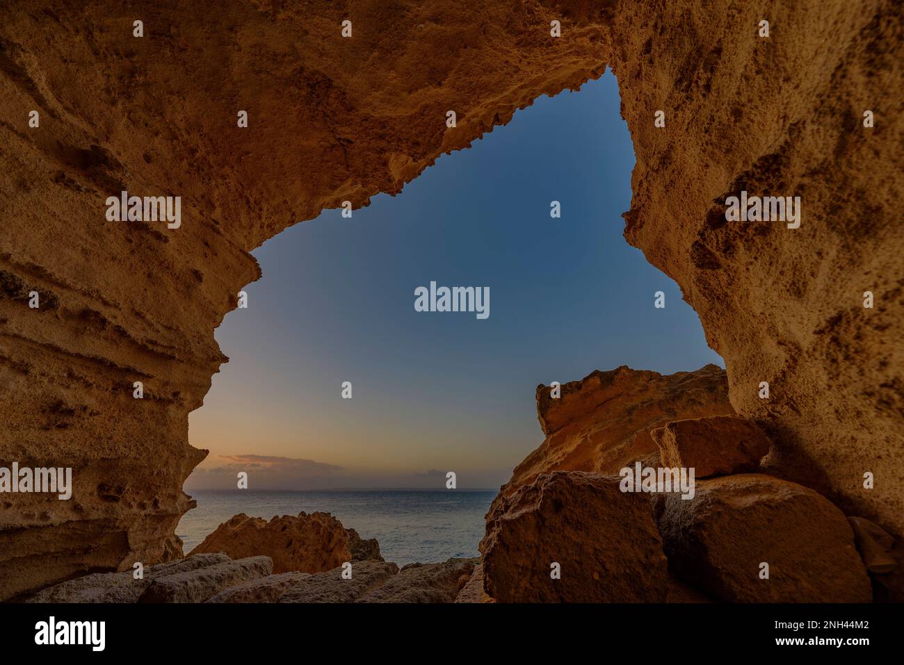 Grottes creusées dans le tuf jaune dans la falaise de Bue Marino aux premières lumières du matin, Favignana Banque D'Images