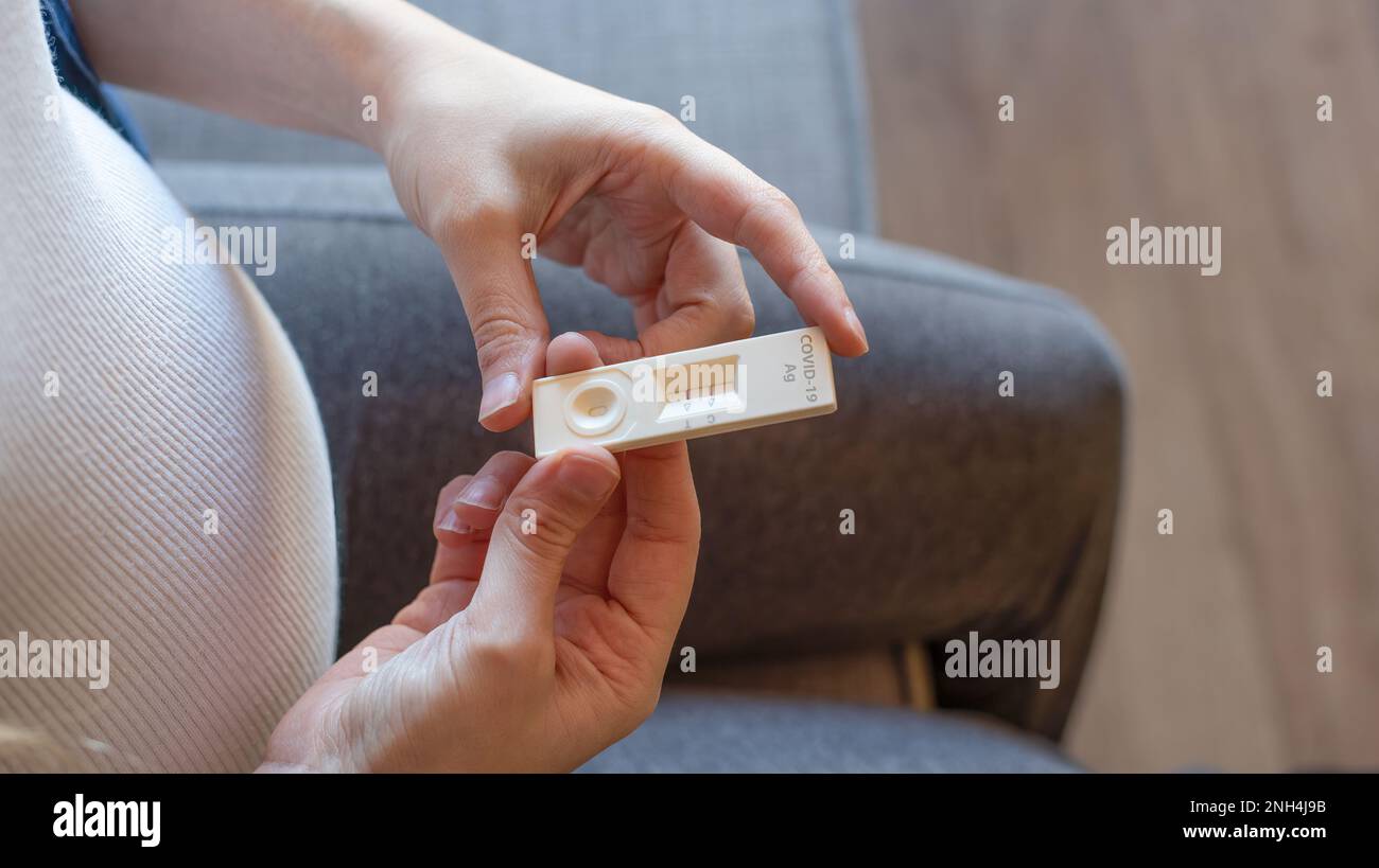 Femme enceinte avec un résultat de test positif en utilisant un dispositif de test rapide pour COVID-19 Banque D'Images