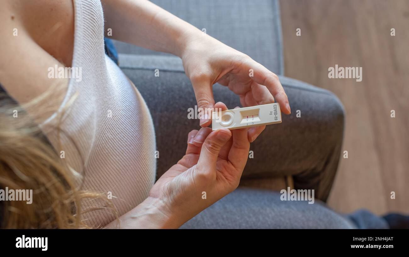 Femme enceinte avec un résultat de test positif en utilisant un dispositif de test rapide pour COVID-19 Banque D'Images