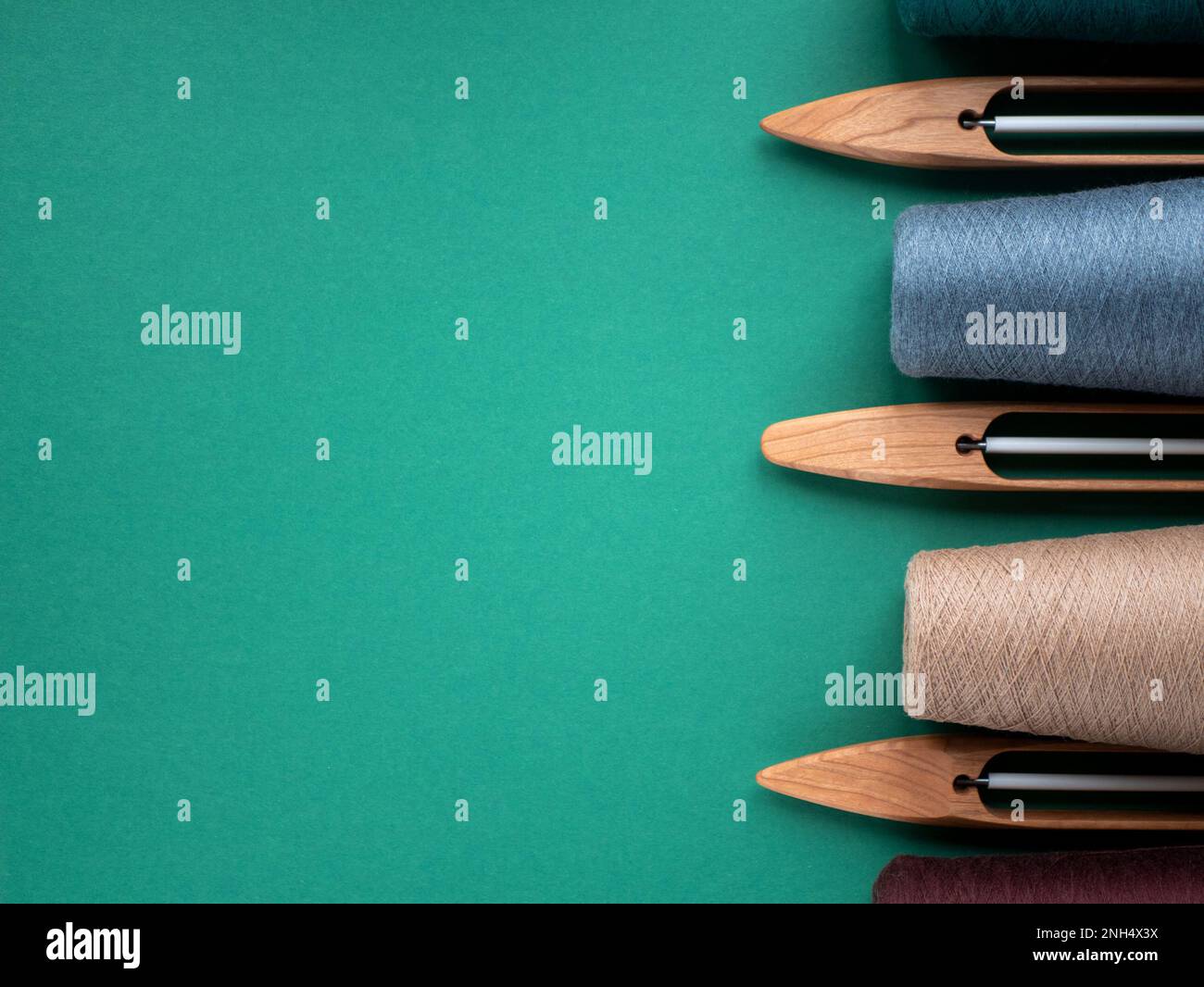 Navettes de bateau en bois pour le métier à main et les cônes avec fil de tons neutres, l'espace de copie. Concept des outils de tissage Banque D'Images