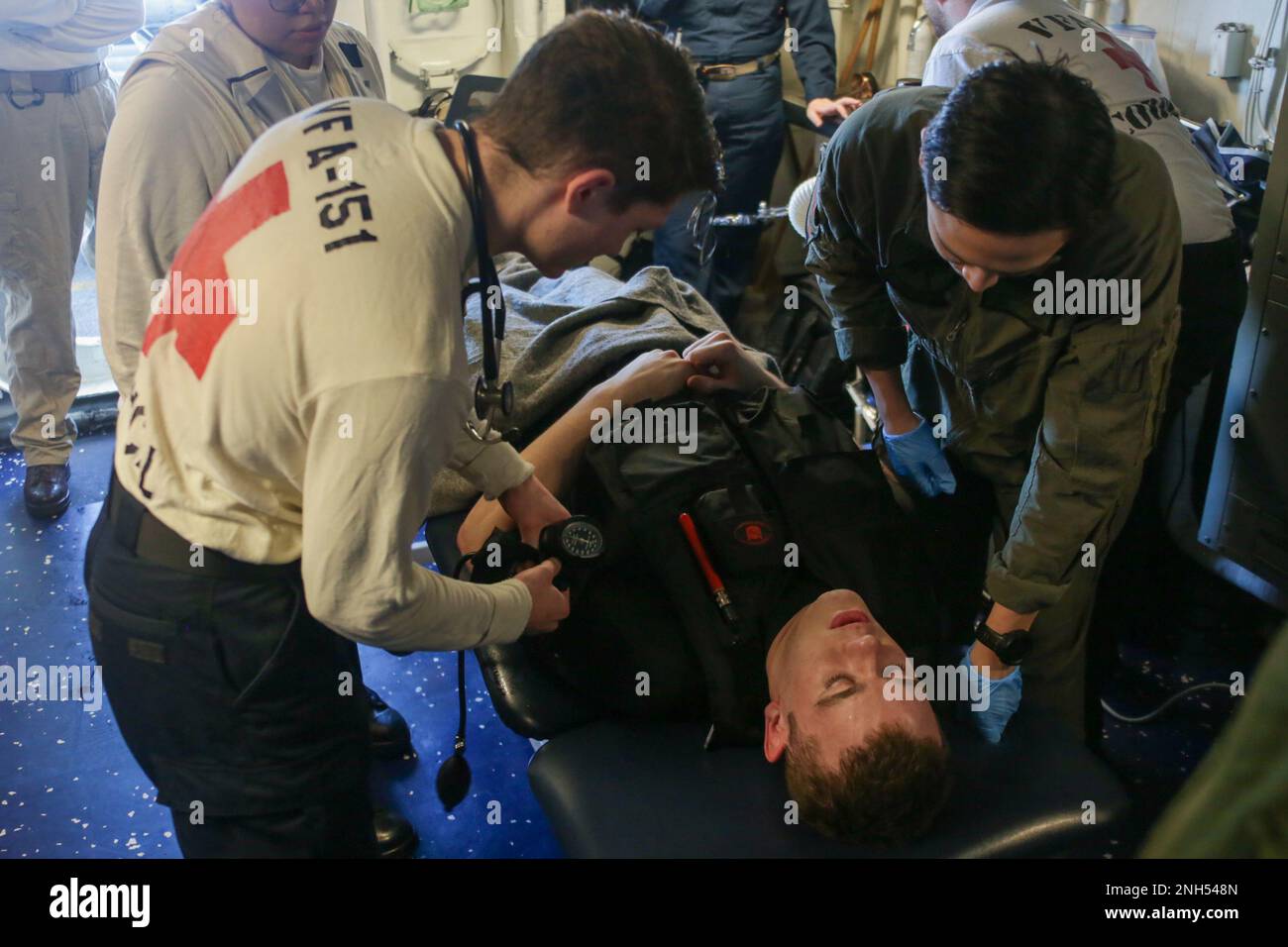 Les marins DE LA MER DES PHILIPPINES (21 juin 2022) vérifient les paramètres vitaux du pompier Jarin Meyer, de Piqua, dans l'Ohio, dans la station de tenue de combat du pont de vol lors d'un exercice de recherche et de sauvetage à bord du porte-avions de la classe Nimitz USS Abraham Lincoln (CVN 72). Abraham Lincoln Strike Group est en cours de déploiement prévu dans la zone d'exploitation de la flotte américaine 7th afin d'améliorer l'interopérabilité par le biais d'alliances et de partenariats tout en servant de force de réaction prête à l'emploi pour soutenir une région libre et ouverte d'Indo-Pacifique. Banque D'Images