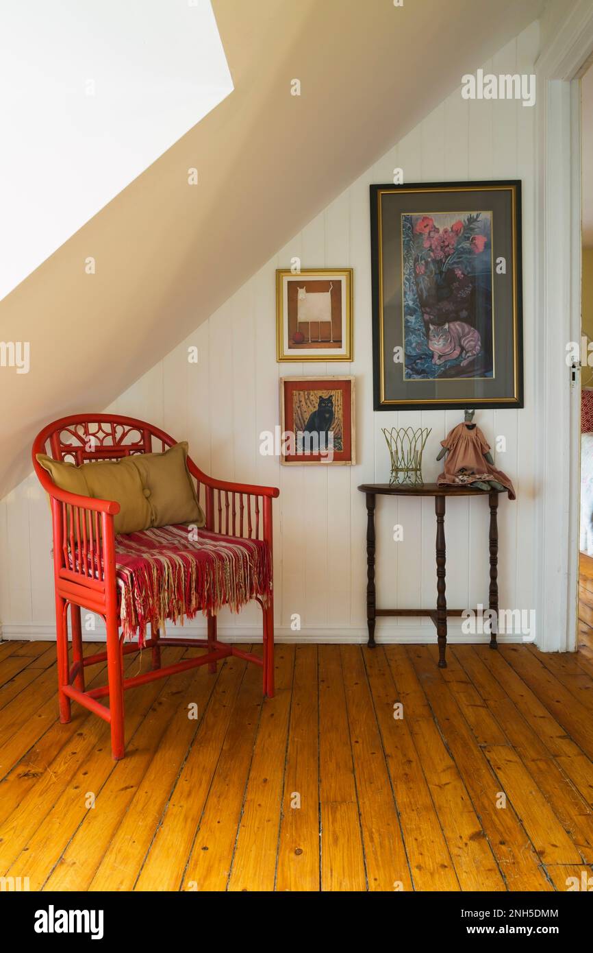 Fauteuil antique en bois rouge et table de console à côté de lath blanc mur à l'étage avec plancher en bois à l'intérieur de la vieille maison vers 1830. Banque D'Images