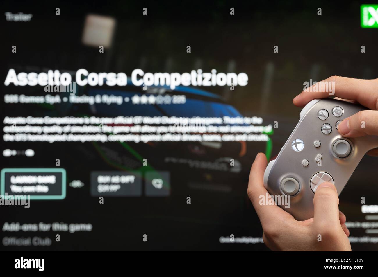 New york, Etats-Unis - 20 février 2023: Homme jouer Assetto Corsa jeu sur console d'ordinateur avec joystick xbox dans la main vue rapprochée Banque D'Images