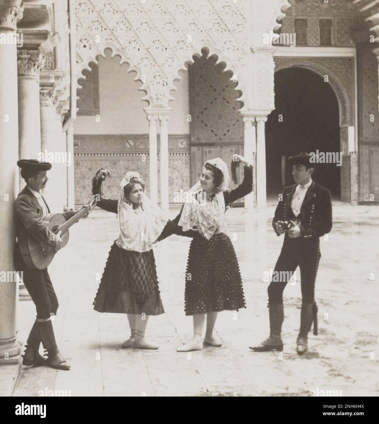 Culture de la vieille Espagne. Danseurs espagnols dans l'Alcazar, Séville, Espagne. 1908 les Alcázars royaux de Séville (espagnol: Reales Alcázares de Sevilla), historiquement connu sous le nom d'al-Qasr al-Muriq et communément connu sous le nom d'Alcázar de Séville, est un palais royal à Séville, en Espagne, construit pour le roi chrétien Pierre de Castille. Il a été construit par des chrétiens castilliens sur le site d'un alcazar Abbadid musulman, ou forteresse résidentielle. Banque D'Images