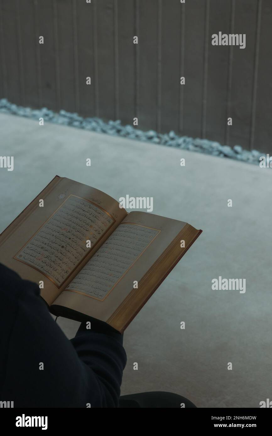 Photo verticale islamique. Homme musulman lisant le Saint Coran dans une mosquée. Photo de fond de l'histoire du concept de Ramadan. Istanbul Turkiye - 11.12.2022 Banque D'Images