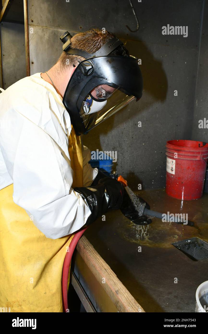 James Bielamowicz, sableuse dans le petit atelier de nettoyage de FRCE, nettoie les revêtements organiques du sous-ensemble d'arbre d'un hélicoptère CH-53. La pièce a été traitée avec un décapant chimique pour enlever les revêtements organiques avant de pouvoir être réparée. FRCE a récemment aidé les États-Unis Le Centre de logistique de l’aviation (ALC) de la Garde côtière à Elizabeth City, en Caroline du Nord, a surmonté un arriéré de pièces qui devaient être dépouillées chimiquement. Banque D'Images