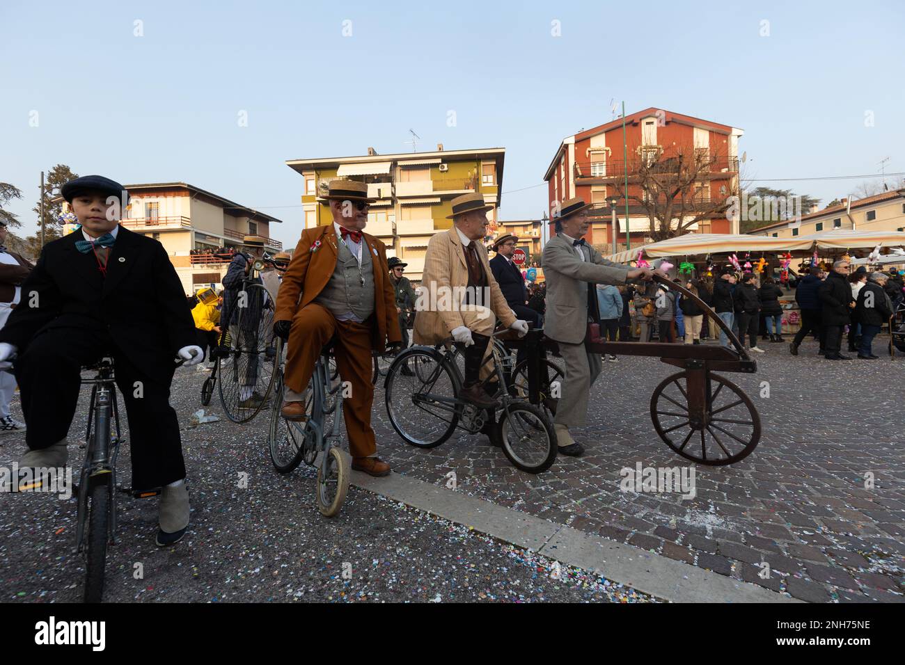 Antique Bicycle Adventure: Carnival-Goer fait une fête de Penny à travers la foule Banque D'Images
