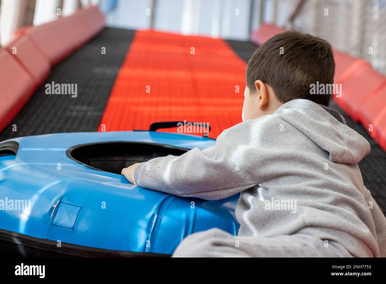 enfant s'amusant dans le centre de jeu en portant sur une colline artificielle Banque D'Images