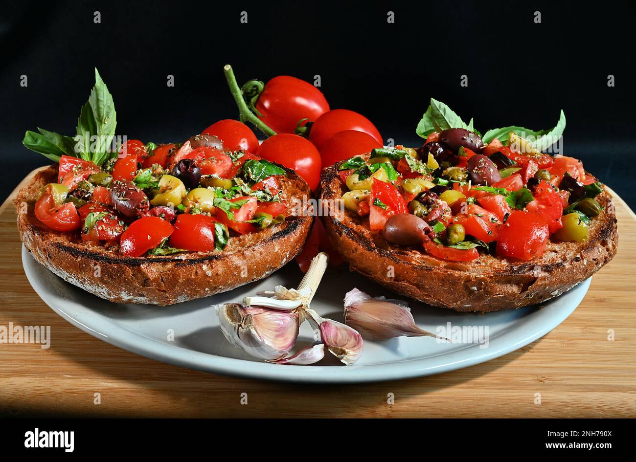 Bruschetta traditionnelle des Pouilles du sud de l'Italie avec tomates fraîches, basilic, olives, origan, huile d'olive. Le régime méditerranéen est ici. Banque D'Images