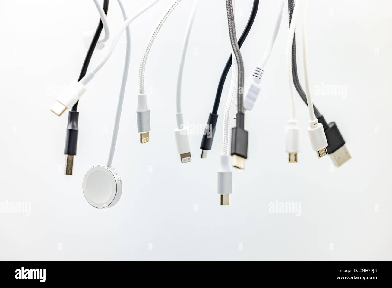Un enchevêtrement de fiches, de prises et de câbles USB exposé dans le studio sur un arrière-plan blanc Banque D'Images