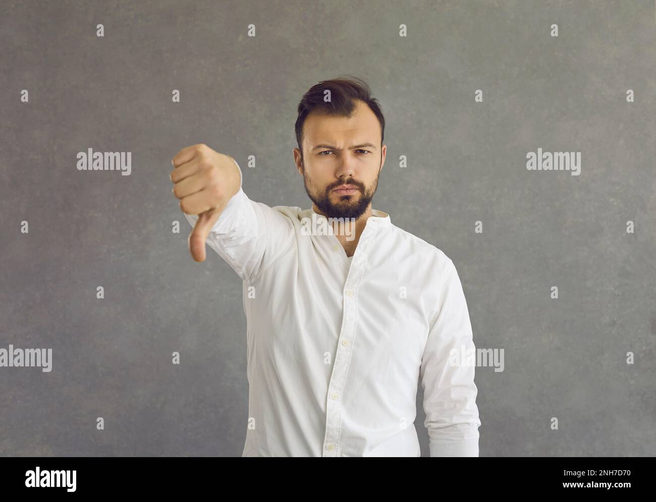 Portrait d'un jeune homme qui donne un pouce debout isolé sur un fond gris Banque D'Images