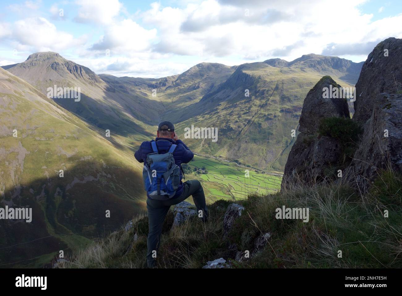 Homme (Hiker) prendre des photos des Wainwrights, du Grand Gable, de Lingmell et de la chaîne de montagnes Scafell depuis Stirrup Crag sur Yewbarrow, Wasdale Head, Banque D'Images