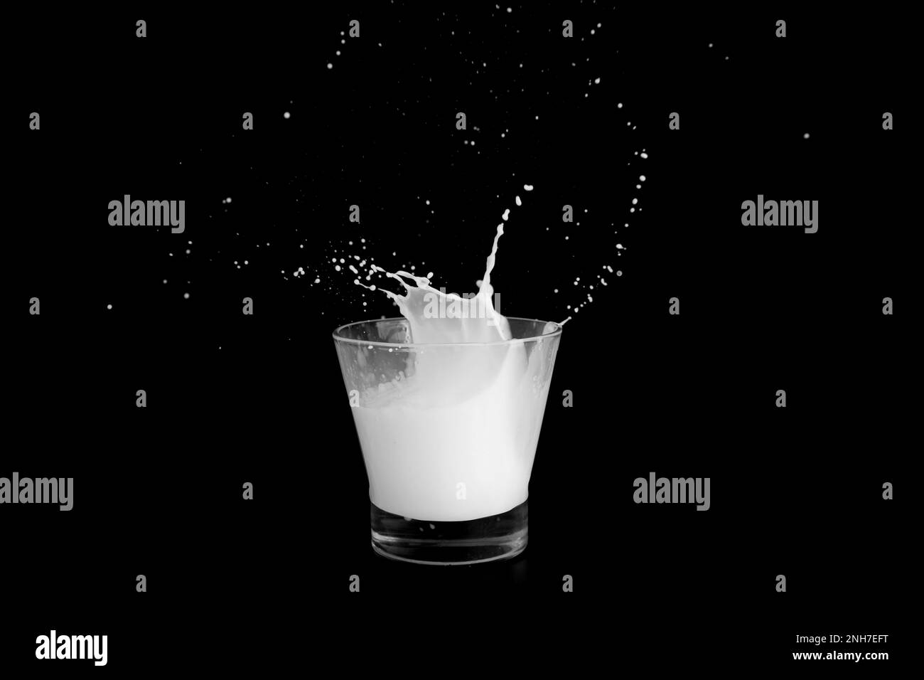 Éclaboussures de lait sur fond noir. Banque D'Images