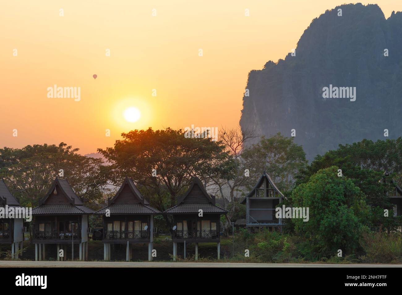 Coucher de soleil avec montgolfière à Vang Vieng, vue sur la montagne, bungalow au bord de la rivière, Vang Vieng, Laos Banque D'Images